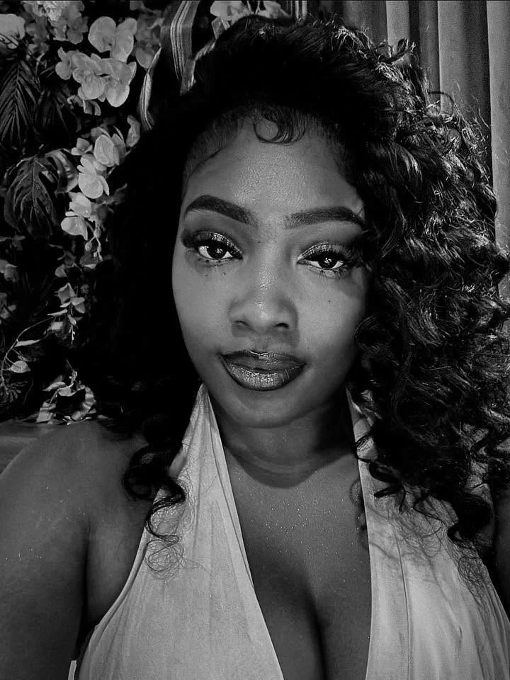Client with a curly half-up install and baby hairs, in black and white
