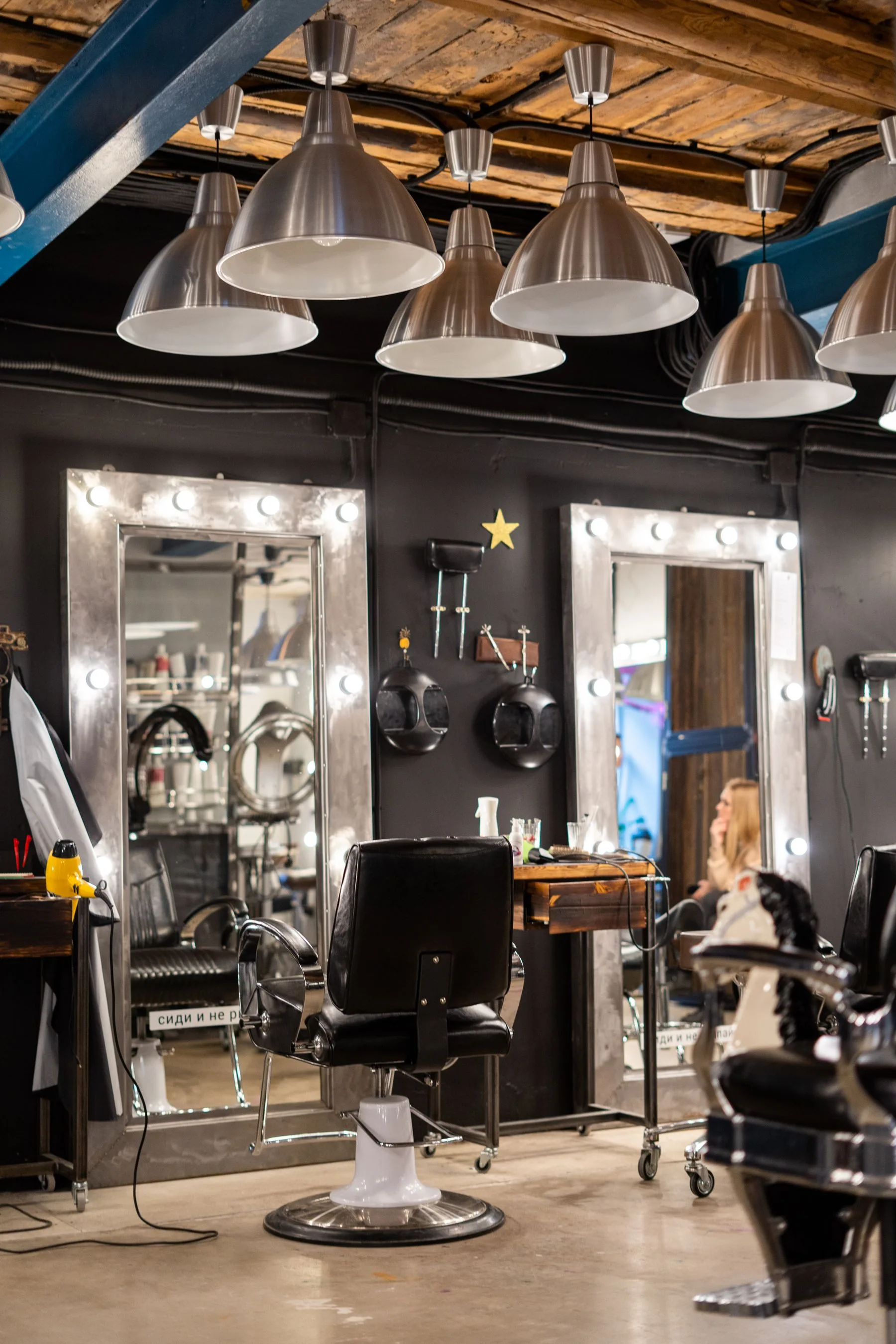 Cozy salon interior with chairs and lit mirrors